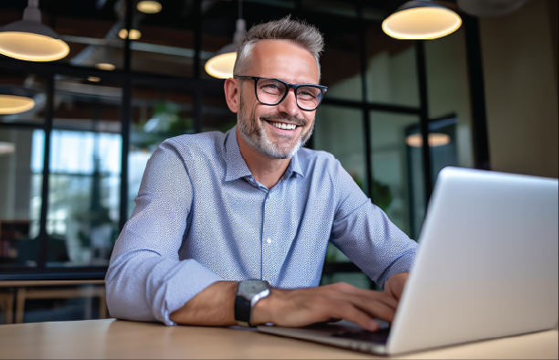 A smiling business professional working on a laptop